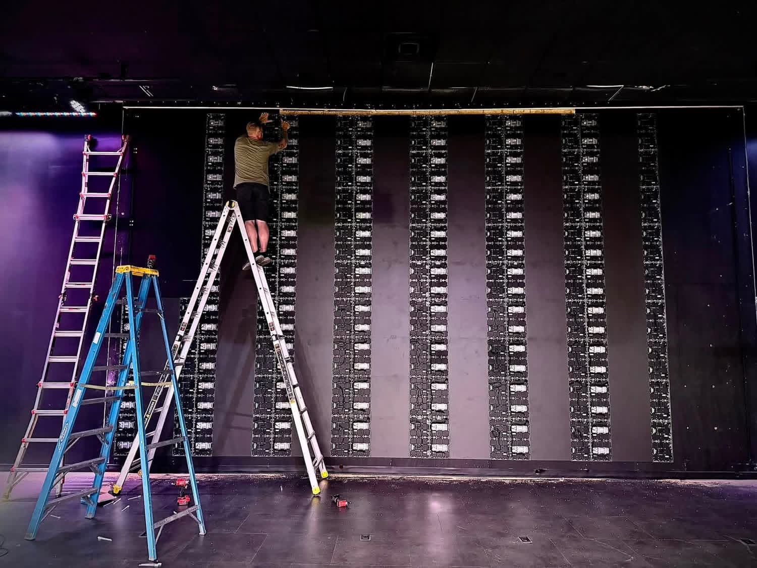 Back of the LEDGEN LED wall with all panels mounted, installer working at the top during build-out at Life Church in Danville