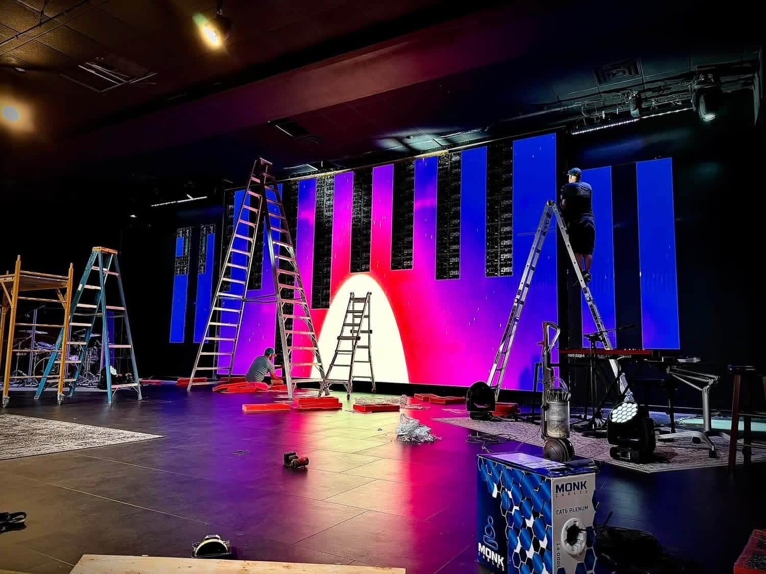 LED wall powered on with a colorful test pattern during installation at Life Church in Danville, Illinois, with ladders in front